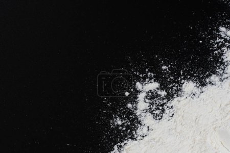 Background of Starch flour powder texture, top view image. cornstarch isolated at dark backdrop.