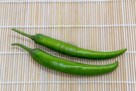 Photo for Green raw long hot chili peppers on a white background. - Royalty Free Image