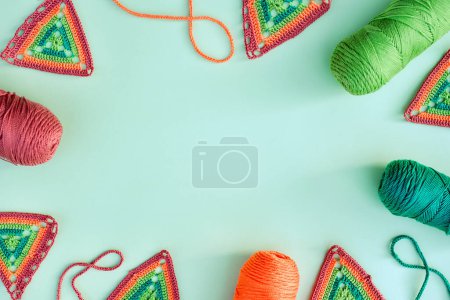 Photo for Frame of crochet motifs, skeins of yarn and crochet cords on light green background. Concept of crochet making. - Royalty Free Image
