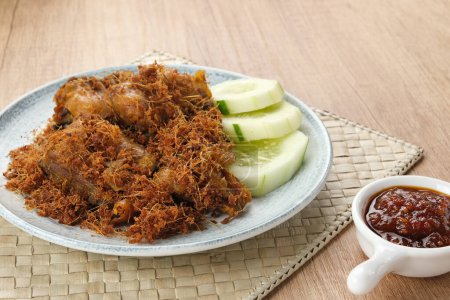 Ayam Goreng Lengkuas, gebratenes Huhn, das mit Gewürzen gekocht und mit geriebenem Galgant bestreut wird. Traditionelle indonesische Küche.  