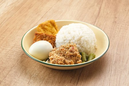 Téléchargez les photos : Nasi Gudangan, riz servi avec divers légumes avec de la noix de coco râpée assaisonnée et divers plats d'accompagnement. Alimentation indonésienne - en image libre de droit