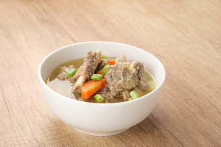 Photo for Sop Iga (Beef ribs soup) made from ribs, carrots, leeks.  Served in white bowl. Indonesian food - Royalty Free Image