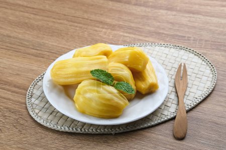Photo for Fresh and ripe jackfruit served on a plate on a wooden table. - Royalty Free Image