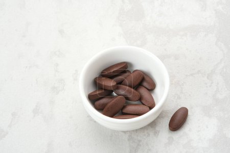 Photo for Herbal medicine in capsules in a wooden spoon - Royalty Free Image