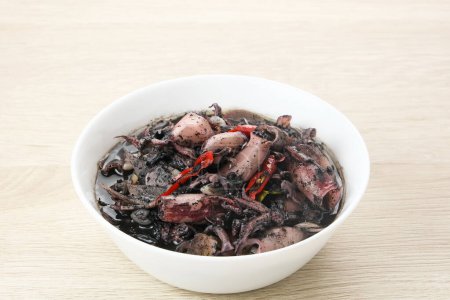 Foto de Sopa negra de calamar (Tumis Cumi Hitam) o calamares fritos en tinta negra, comida tradicional indonesia - Imagen libre de derechos