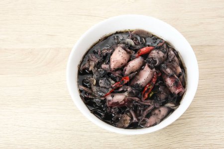 Tintenfischsuppe (Tumis Cumi Hitam) oder gebratener Tintenfisch in schwarzer Tinte, traditionelle indonesische Küche