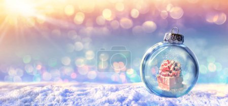 Photo for Red gift box in a snow ball on winter background - Royalty Free Image