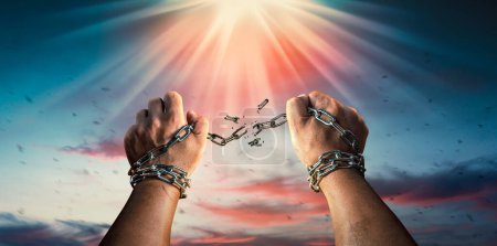 Foto de Manos en puños rompiendo una cadena de libertad. El concepto de ganar libertad. - Imagen libre de derechos