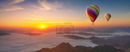 Photo for Colorful hot air balloons flying over mountain misty morning sunrise - Royalty Free Image