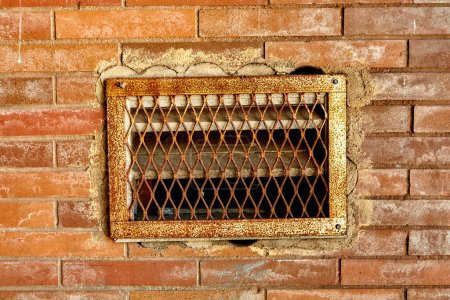 Photo for Rusty Venting Grate in Red Brick Wall - Royalty Free Image