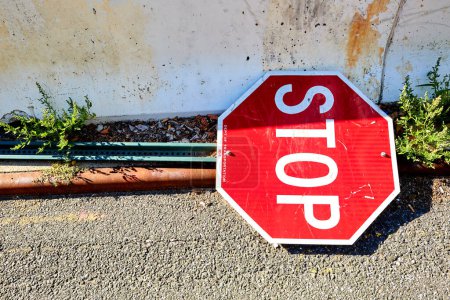 Foto de Stop Sign Laying on the Street Next to Barrier, Right of Frame - Imagen libre de derechos