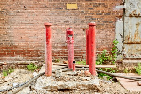 Red Pipes and Pump Rising from Concrete Pad