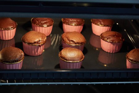 Photo for Small Chocolate Souffles Baking in Oven - Royalty Free Image
