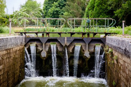 Agua corriendo hacia una esclusa del canal en el río Yonne