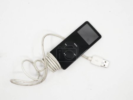 Photo for Closeup of a black vintage mp3 music player known as apple ipod nano with charging cable isolated in a white background - Royalty Free Image