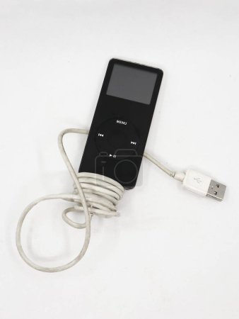 Photo for Closeup of a black vintage mp3 music player known as apple ipod nano with charging cable isolated in a white background - Royalty Free Image