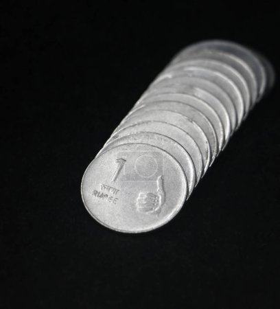 Photo for Closeup of rare vintage indian 1 (one) rupee coins in silver arranged in a row isolated in a black background - Royalty Free Image