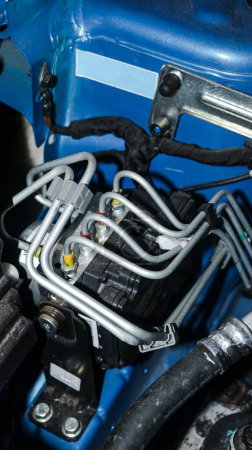 an electronic control unit(ECU) with wired connections controlling various operations of a vehicle located near the engine on the hood 