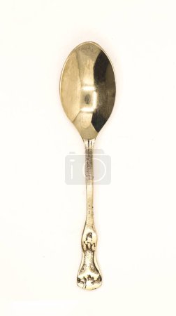 Foto de Una cuchara de bronce antiguo brillante, limpia y antigua utilizada por la realeza para la subasta aislada en un fondo blanco - Imagen libre de derechos