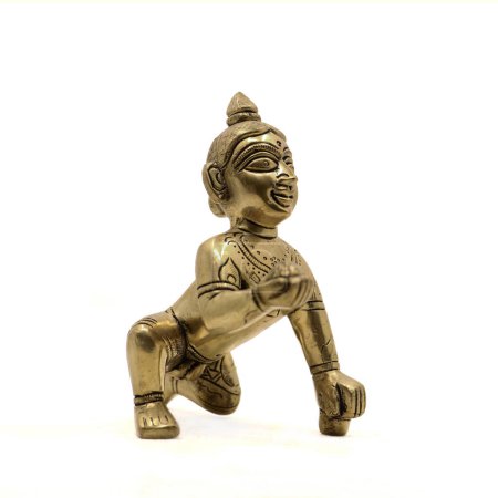 vintage figura dorada de bebé gatear señor krishna también llamado gopal con laddu dulce en su mano aislado en un fondo blanco