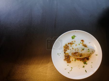 Photo for Lithuanian national dish zeppelins or Cepelinai or cepelins or didzkukuliai with fried bacon and herbs on white plate on black table - Royalty Free Image