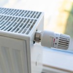 Heating radiator with adjustment knob set to the maximum value due to frost and low temperature. High prices for heat and utilities.