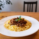 Plate with traditional Italian pasta spaghetti bolognese on a wooden table in the restaurant