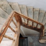 The steps of a wooden spiral staircase in an old building. An old wooden staircase in an old building with white walls.