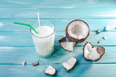 Téléchargez les photos : Vue du dessus du lait de coco en verre avec des pailles avec des fruits de coco sur une table en bois. Concept de lait alternatif. Une boisson tropicale. De la nourriture exotique. Focus sélectif - en image libre de droit