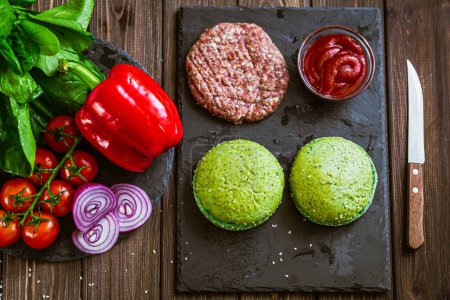 Photo for From above shot of process of making hamburger with vegetables, green buns and artificial meat on board. Vegetarian food - Royalty Free Image