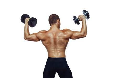 Téléchargez les photos : Back view of athletic muscular man doing exercises with dumbbells isolated on white background. Copy Space - en image libre de droit
