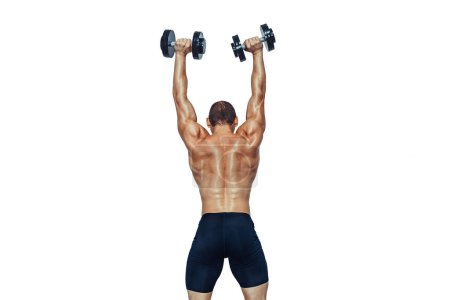Téléchargez les photos : Back view of athletic muscular man who lifting up the dumbbells isolated on white background. copy Space - en image libre de droit