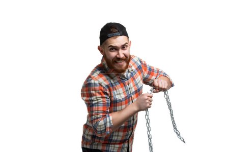 Photo for Beared man in cap and checked shirt emotionally doing crash test with chain on white background. Copy Space - Royalty Free Image