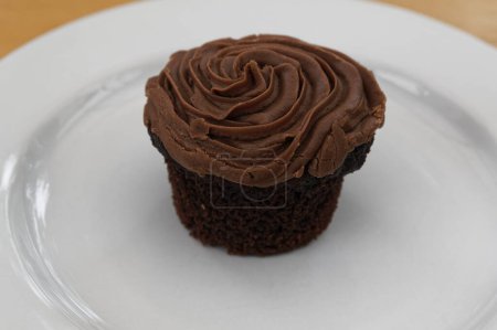 Photo for Chocolate icing tops a chocolate cup cake - Royalty Free Image
