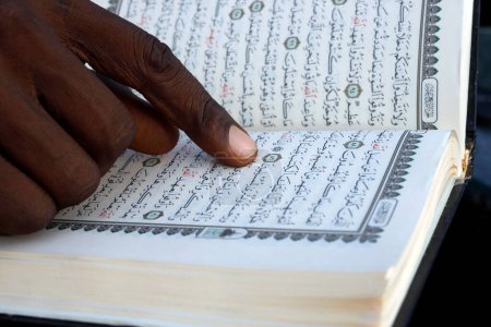Téléchargez les photos : African muslim man reading the Quran. Close-up on hands. Togo. - en image libre de droit
