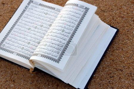 Téléchargez les photos : Open Quran on sand beach. - en image libre de droit