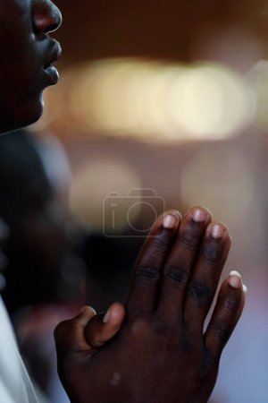 Téléchargez les photos : Église africaine. Messe catholique du dimanche. Homme priant. Gros plan sur les mains. Agbonou Koeroma. Togo. - en image libre de droit