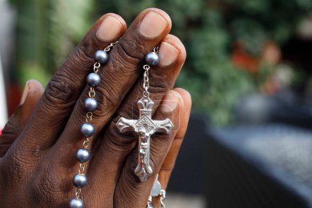 Téléchargez les photos : Un Africain priant le chapelet. Gros plan sur les mains. Lome. Togo. - en image libre de droit