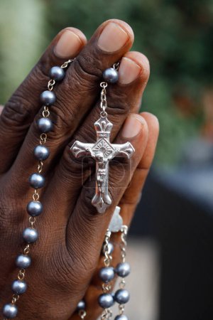 Foto de Hombre africano rezando el rosario. Primer plano en las manos. Lomé. Togo.. - Imagen libre de derechos