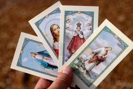 Téléchargez les photos : Selction of catholic images in hands. Close-up - en image libre de droit