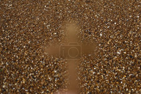 Téléchargez les photos : Blurred image. Christian cross against sand beach. - en image libre de droit