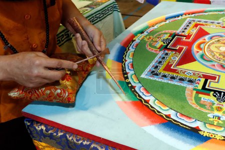 Téléchargez les photos : Mandala de sable bouddhiste tibétain. Bodhisattva Vajrasattva. Moine tibétain travaillant sur le mandala de sable. Gros plan. France. - en image libre de droit