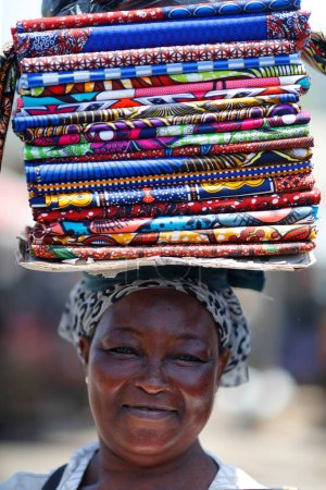 Téléchargez les photos : Woman  selling  imported chinese wax print fabric for traditional african dress.  Lome. Togo. - en image libre de droit