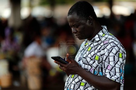 Téléchargez les photos : African man using a smarphone.  Togo. - en image libre de droit
