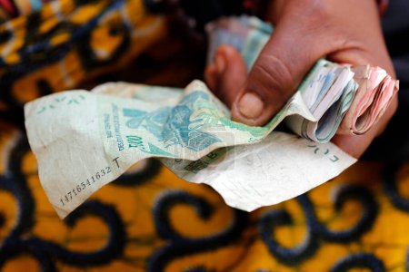 Téléchargez les photos : Woman using CFA Francs. Banknotes. Close-up.  Lome. Togo. - en image libre de droit