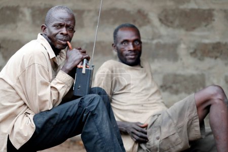 Téléchargez les photos : African village. Men listining radio. Datcha-Attikpaye. Togo. - en image libre de droit