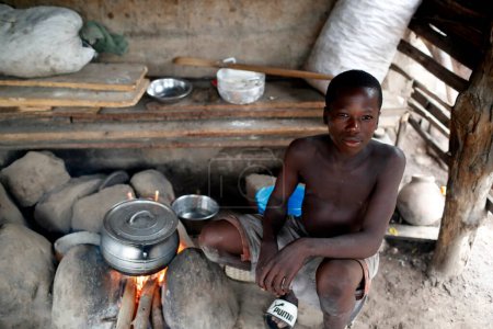 Téléchargez les photos : African kitchen in a village.  Boy cooking. Daily life.  Datcha-Attikpaye. Togo. - en image libre de droit