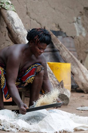 Téléchargez les photos : African woman making cassava flour. Daily life.  Datcha-Attikpaye. Togo. - en image libre de droit