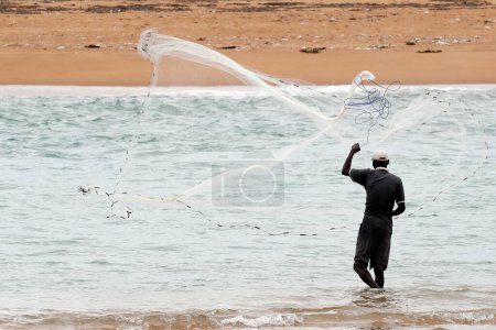 Téléchargez les photos : African fisherman throwing net into the sea in traditional way.  Aneho. Togo. - en image libre de droit
