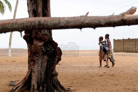 Téléchargez les photos : Return from school. School boys on the beach.  Aneho. Togo. - en image libre de droit